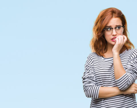 Young woman over isolated background wearing glasses looking stressed and nervous.