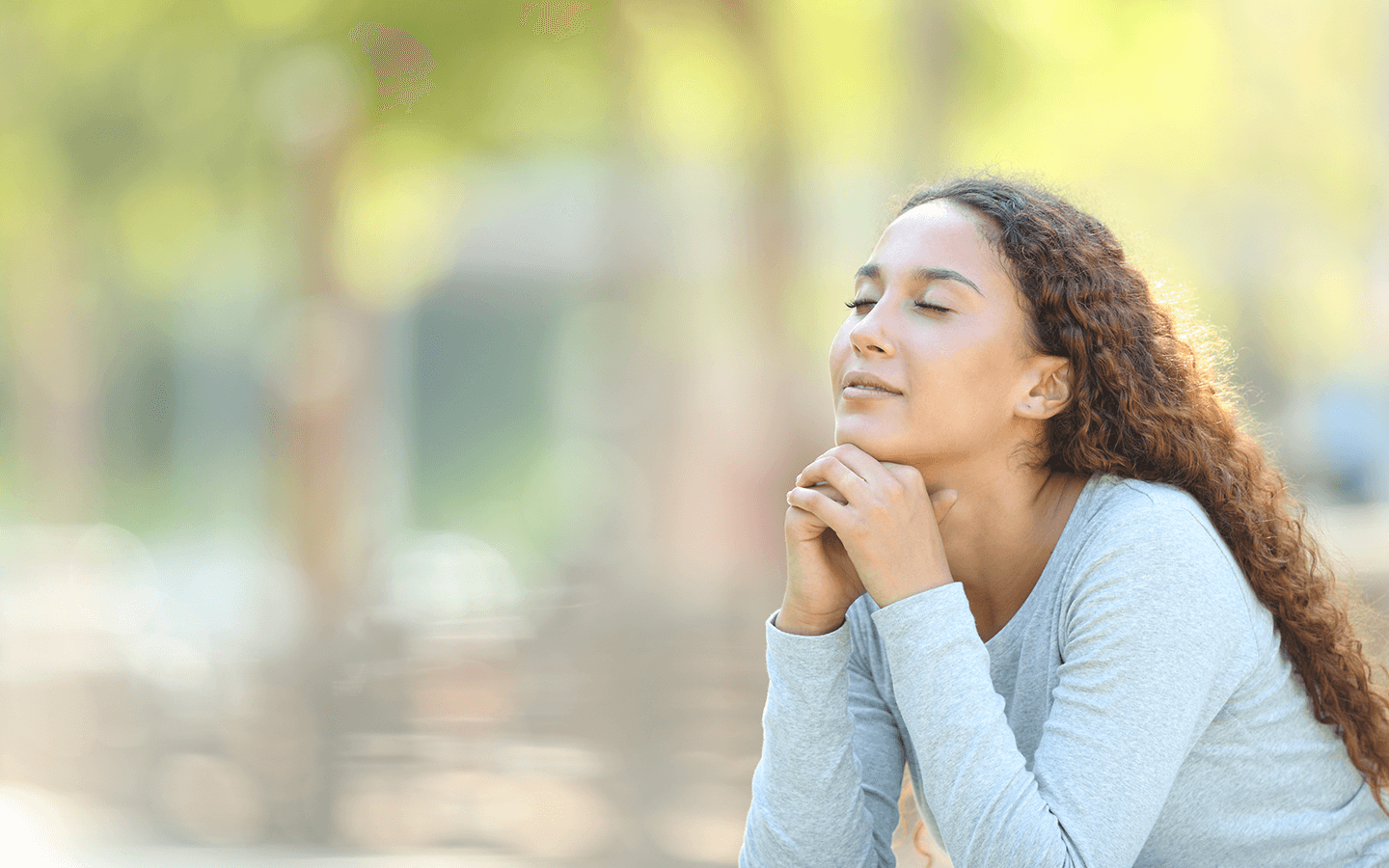 Young woman with eyes closed and serene expression, practising mindfulness to reduce anxiety